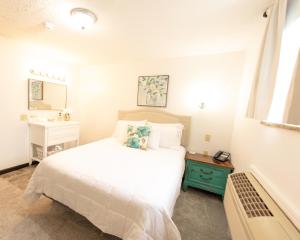 um quarto com uma cama branca e um lavatório em EC Reed's Mercantile and Hotel em Marble Hill