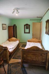 two beds in a room with green walls at Magdi vendégház in Šupljak