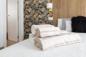 stos poduszek siedzących na łóżku w obiekcie Penthouse in Estepona - Malaga w mieście Estepona +28 zdjęć