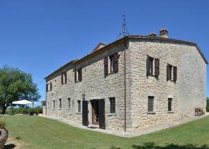 un grande edificio in pietra su una collina erbosa di San Valentino Castle near Todi ad Acqualoreto