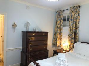 een slaapkamer met een bed, een dressoir en een raam bij William's Grant Inn Bed and Breakfast in Bristol