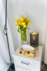 a vase of yellow flowers and a box on a table at UNLIMITED - schön & zentral wohnen perfekt für kurze Aufenthalte in Bamberg