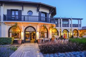 a large white house with a courtyard in front of it at Hotel La Co(o)rniche in Pyla-sur-Mer