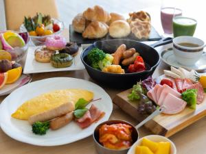 une table avec des assiettes et des bols de denrées alimentaires différentes dans l'établissement ANA Crowne Plaza Resort Appi Kogen, an IHG Hotel, à Hachimantai