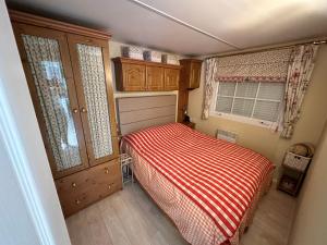 mała sypialnia z łóżkiem i oknem w obiekcie Mobile Home, Camping Le Dattier, Fréjus, South of France w Fréjus