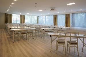 uma grande sala com mesas, cadeiras e janelas em Resun Hotel em Ancara