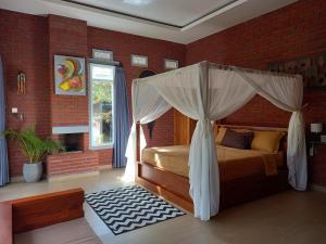 a bedroom with a bed with a canopy at Kubu Kawi in Munduk