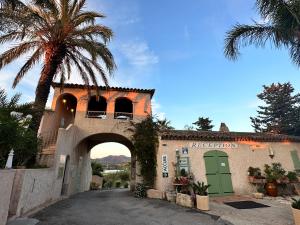 a building with an archway and a palm tree at Mobile Home, Camping Le Dattier, Fréjus, South of France in Fréjus