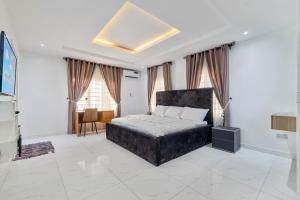 a bedroom with a bed and a desk and windows at Gorgeous Short-let Apartment Lekki in Lekki