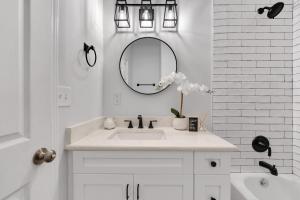 Baño blanco con lavabo y espejo en Zen Home in the Heart of Atlanta, en Atlanta