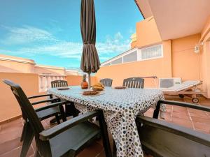 - une table avec des chaises et un parasol sur le balcon dans l'établissement Dream House, à Callao Salvaje