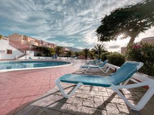 deux chaises longues assises à côté d'une piscine dans l'établissement Dream House, à Callao Salvaje