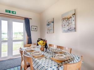 a dining room with a table and chairs at Jura in Drummore