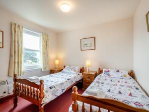 a bedroom with two twin beds and a window at Jura in Drummore