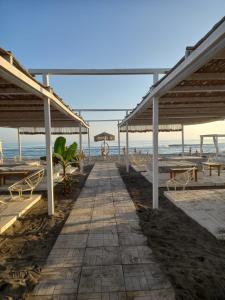 a walkway on a beach with tables and benches at Vienna Montenegro Lleshi in Donji Štoj