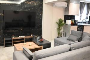 un soggiorno con 2 divani e una TV a schermo piatto di Harmony Seaside House a Ialyssos