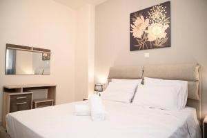 1 dormitorio con cama blanca y espejo en Harmony Seaside House, en Ialisos