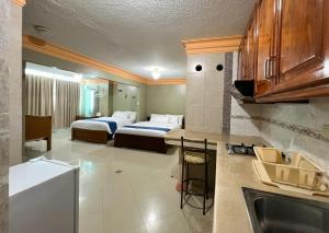 Apart Hotel Hamilton في مانتا: غرفة فندقية بسريرين ومطبخ