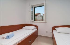 two beds in a small room with a window at Nice Apartment In Sutivan With Wifi in Sutivan