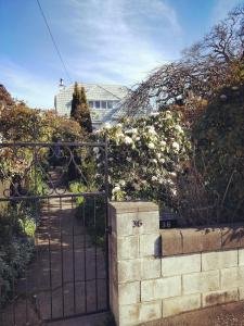 a gate to a garden with flowers and a house at Seaview Sefton in Timaru