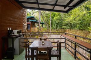 einen Tisch und Stühle auf einem Balkon mit einer Mikrowelle in der Unterkunft Riverside Villas in Manuel Antonio