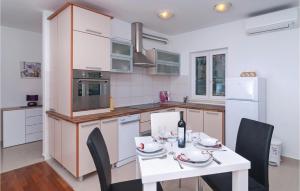 a kitchen with a white table and chairs and a kitchen with white appliances at Pet Friendly Apartment In Sutivan With House Sea View in Sutivan