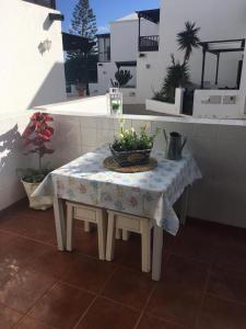 - une table avec un bol de fleurs dans l'établissement Duplex 3 dormitorios con parking privado, à Costa Teguise