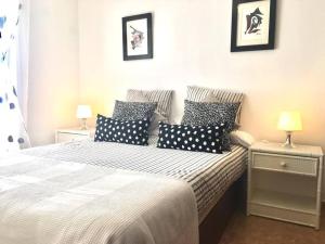 - une chambre avec un lit et des oreillers noirs et blancs dans l'établissement Duplex 3 dormitorios con parking privado, à Costa Teguise