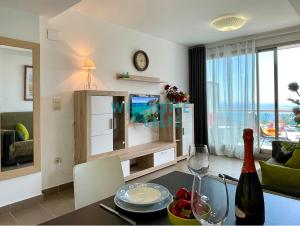 uma sala de estar com uma mesa e uma garrafa de vinho em LIMA con piscina y vista al mar em Calpe