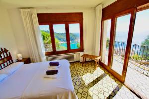 a bedroom with a bed and a view of the ocean at V&V LLORET- VILLA MEDITERRANIA preciosa villa con vistas panorámicas al mar y a solo 120m de la playa Cala Canyelles!! in Lloret de Mar