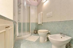 Baño blanco con aseo y lavamanos en La Dimora Dante, en Roma