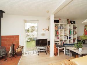 a living room with a tv and a book shelf at 6 person holiday home in Nyk bing Sj in Højby
