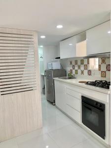 cocina con armarios blancos y fogones en Casa Nómada - To work and enjoy!, en Santa Marta