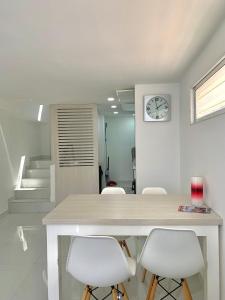 comedor con mesa y sillas blancas en Casa Nómada - To work and enjoy!, en Santa Marta