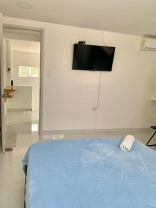 1 dormitorio con 1 cama y TV en la pared en Casa Nómada - To work and enjoy!, en Santa Marta