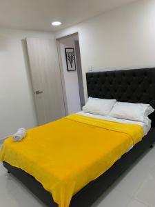 Una cama con una manta amarilla en una habitación en Casa Nómada - To work and enjoy!, en Santa Marta