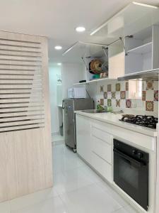 cocina con armarios blancos y fogones en Casa Nómada - To work and enjoy!, en Santa Marta
