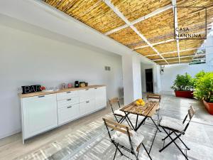 cocina con mesa y sillas en una habitación en Casa Nannina - Seaview Terrace with Jacuzzi in Capri en Capri