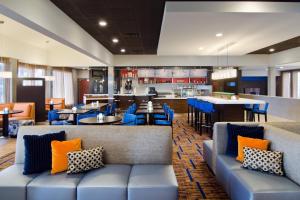 a restaurant with blue couches and a bar at Courtyard St. Louis Westport Plaza in Maryland Heights