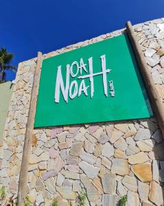 a sign for a north north sign on a stone wall at Pousada Noah Noah Milagres in São Miguel dos Milagres