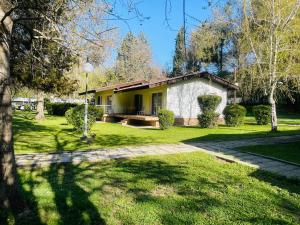 a house in a park with a grass yard at Fuk-tak's bungalow in Star Dojran