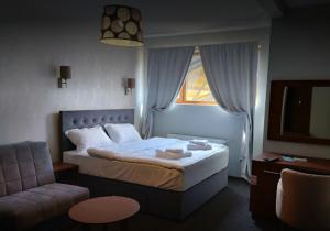 a bedroom with a bed and a couch and a window at Keystone Villas in Kolašin