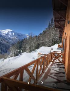 a wooden balcony with a view of a snow covered mountain at Keystone Villas in Kolašin