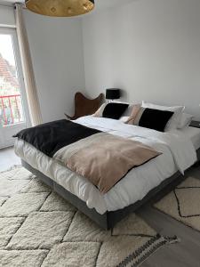 a bedroom with a large bed in a white room at La Maison de Jeanne in Sélestat