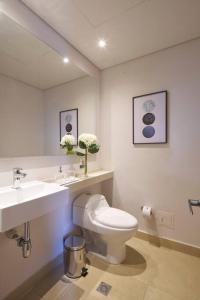 a bathroom with a toilet and a sink and a mirror at Caluce Apt 2A by Letoh in Chía