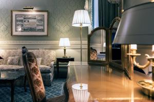 a living room with a table and a mirror at Eurostars Grand Hotel Wien in Vienna