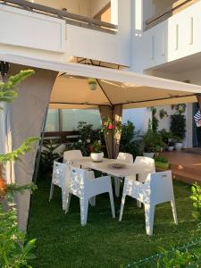 une table et des chaises blanches sous une tente dans l'établissement Appartement de vacances BERALMAR CHEZ HOUDA, à Assilah