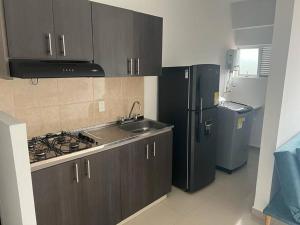 a kitchen with a black refrigerator and a sink at Confortable apto en Armenia 1505 in Armenia
