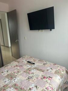 a bedroom with a bed with a tv on the wall at Confortable apto en Armenia 1505 in Armenia