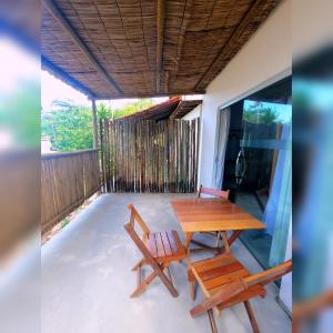 een houten tafel en 2 stoelen op een patio bij Pousada Siriba in Caravelas